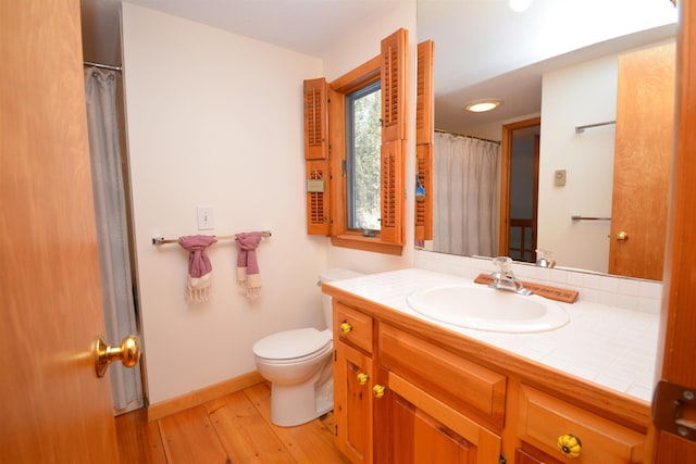 bathroom featuring hardwood / wood-style flooring, toilet, and vanity