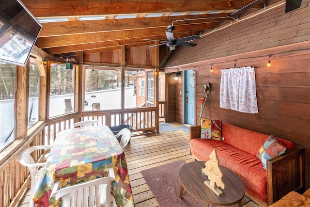 sunroom featuring ceiling fan and vaulted ceiling with beams