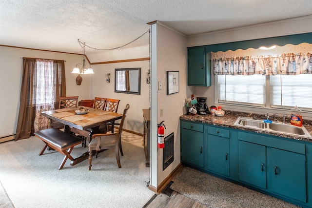 dining area with a textured ceiling, ornamental molding, a healthy amount of sunlight, and sink