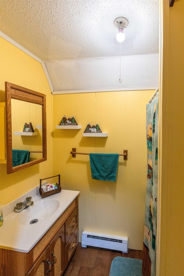 bathroom with baseboard heating, a textured ceiling, lofted ceiling, wood-type flooring, and vanity