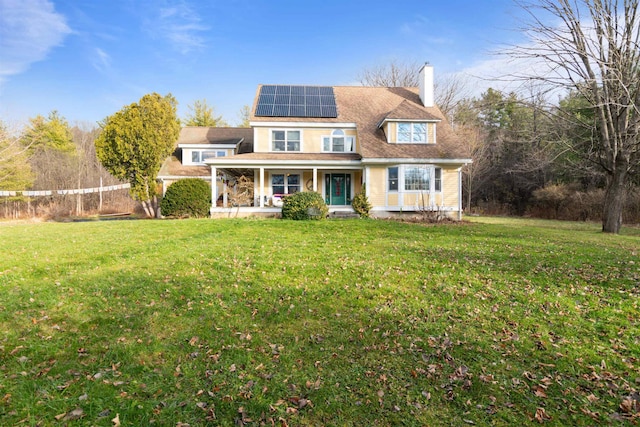 view of front of house featuring solar panels, a front yard, and a porch