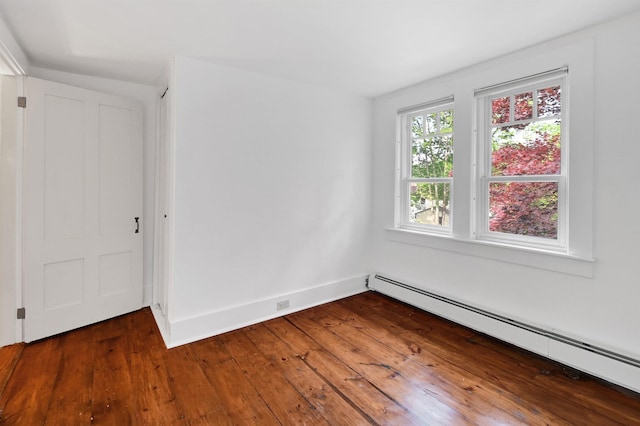 spare room with a baseboard radiator and dark hardwood / wood-style flooring