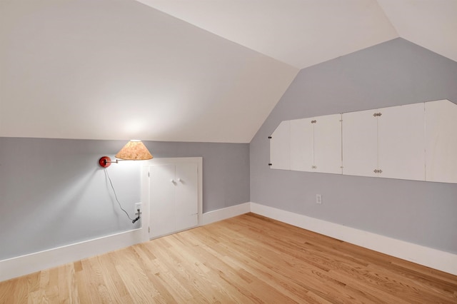 additional living space with lofted ceiling and light hardwood / wood-style floors