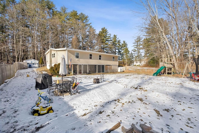 snow covered property with a playground