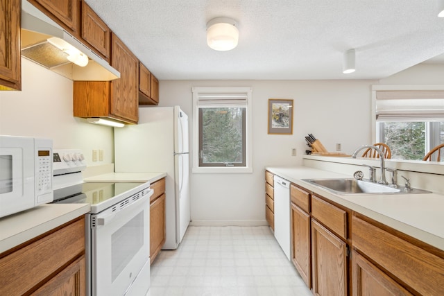 kitchen featuring a textured ceiling, sink, and white appliances