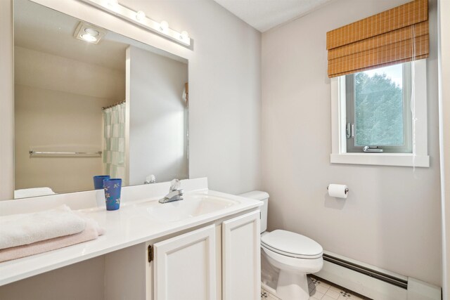 bathroom featuring toilet, vanity, and baseboard heating