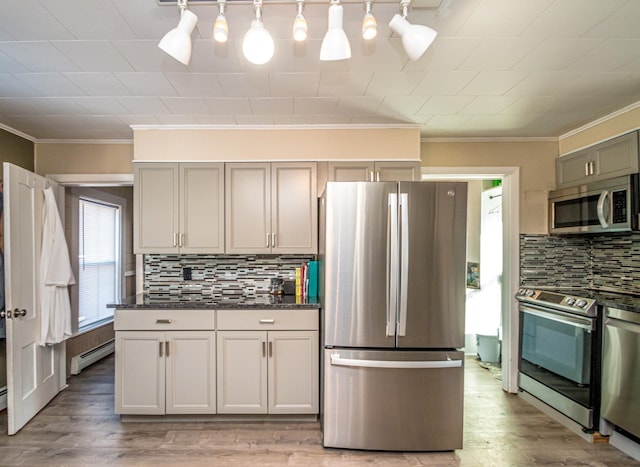 kitchen featuring tasteful backsplash, baseboard heating, stainless steel appliances, and pendant lighting