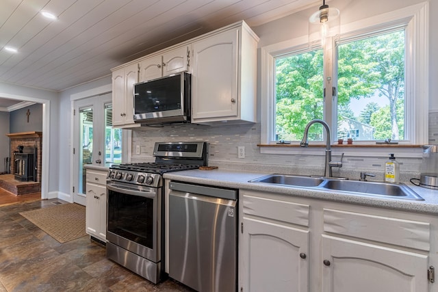 kitchen with stainless steel appliances, wood ceiling, white cabinetry, and sink