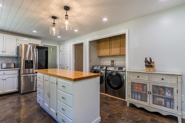 kitchen featuring pendant lighting, stainless steel refrigerator with ice dispenser, washer and clothes dryer, white cabinets, and wooden ceiling