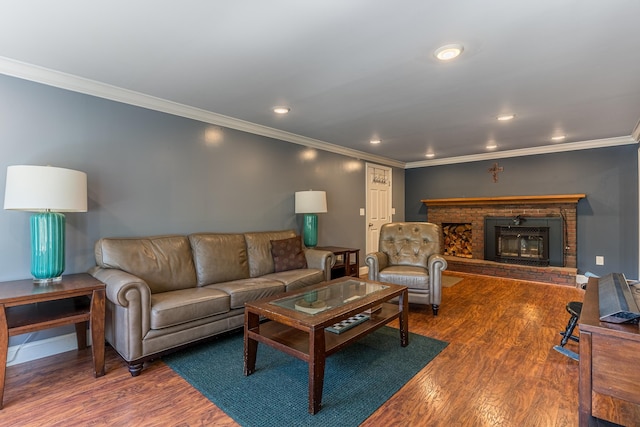 living room with a brick fireplace, ornamental molding, and wood-type flooring