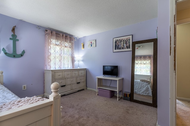 bedroom featuring light colored carpet and a textured ceiling