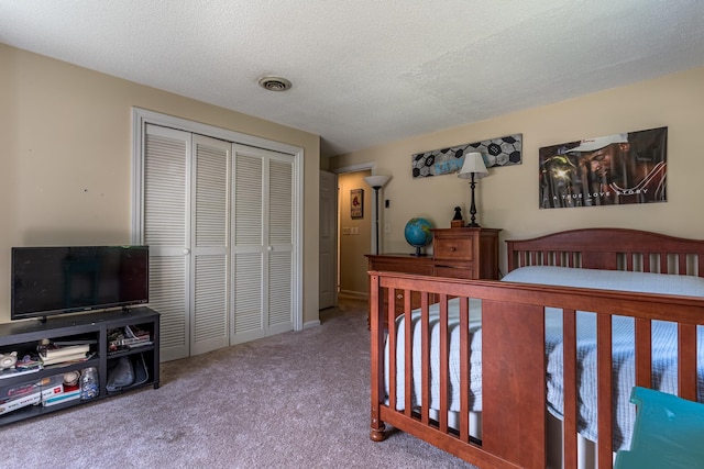 bedroom with carpet, a closet, and a textured ceiling