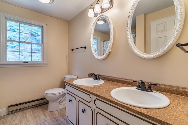 bathroom featuring toilet, hardwood / wood-style floors, vanity, and a baseboard radiator