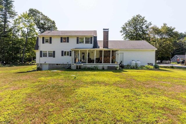 rear view of property with a yard and a sunroom