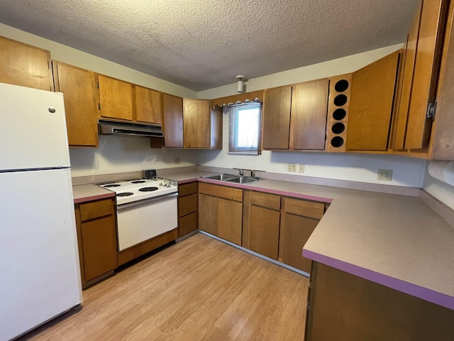 kitchen featuring light hardwood / wood-style floors, sink, white appliances, and a textured ceiling