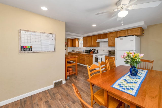 dining space with ceiling fan, dark hardwood / wood-style floors, and sink