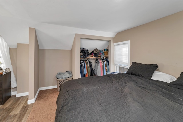 bedroom with a closet, lofted ceiling, and light hardwood / wood-style floors