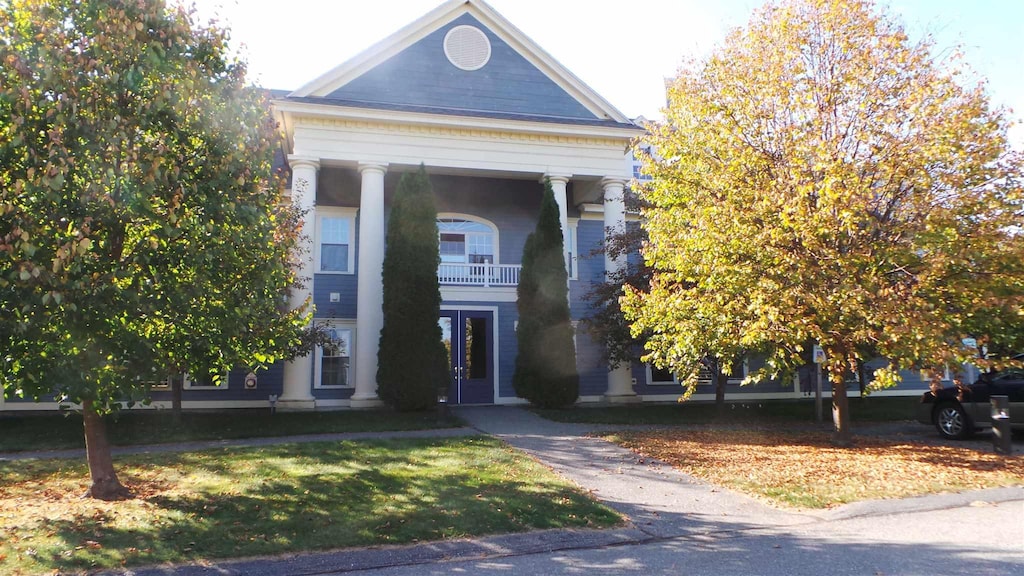 greek revival inspired property with a balcony