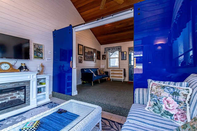 carpeted living room featuring vaulted ceiling, wood ceiling, a barn door, and wood walls