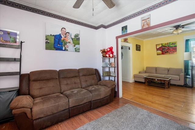 living room featuring ceiling fan, wood-type flooring, and ornamental molding