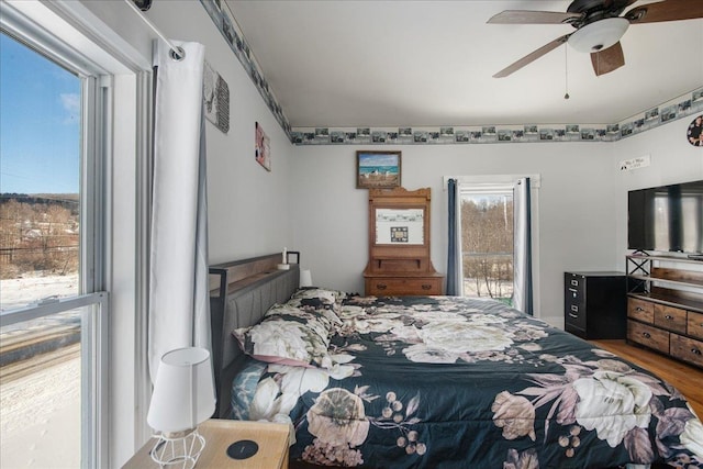 bedroom with ceiling fan, hardwood / wood-style floors, and multiple windows