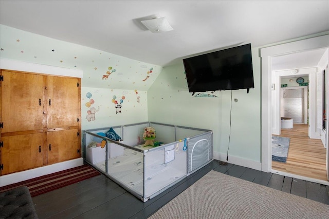 unfurnished bedroom featuring vaulted ceiling and dark hardwood / wood-style flooring