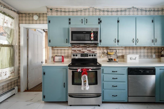 kitchen featuring appliances with stainless steel finishes, backsplash, blue cabinetry, baseboard heating, and crown molding