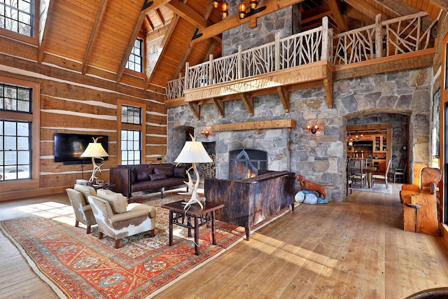 living room with high vaulted ceiling, wood-type flooring, a fireplace, and plenty of natural light