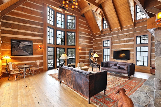 living room featuring high vaulted ceiling, beamed ceiling, light hardwood / wood-style floors, and wooden ceiling