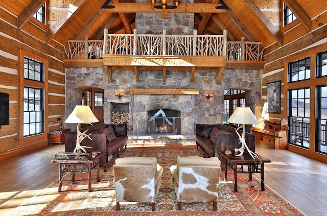 living room with high vaulted ceiling, wood-type flooring, a fireplace, and a skylight