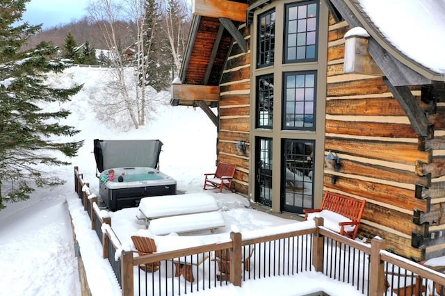 snow covered property featuring a hot tub