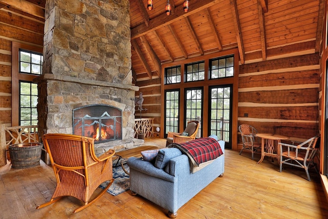 living room with a fireplace, beam ceiling, light hardwood / wood-style flooring, high vaulted ceiling, and wooden ceiling