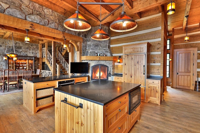 kitchen featuring a center island, wood ceiling, decorative light fixtures, black microwave, and beamed ceiling