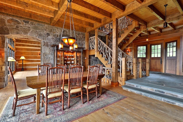 unfurnished dining area featuring hardwood / wood-style floors, beamed ceiling, and wooden ceiling