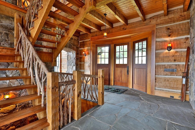 interior space featuring wood ceiling, wood walls, and beamed ceiling