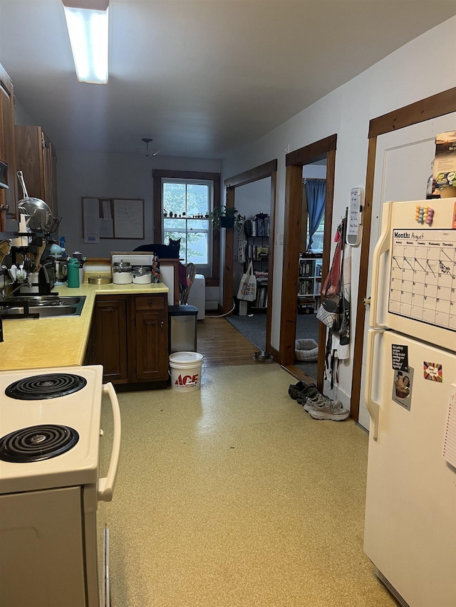 kitchen with kitchen peninsula, white appliances, and dark brown cabinets