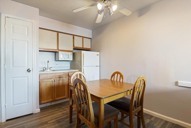 dining room with ceiling fan, dark wood-type flooring, and sink