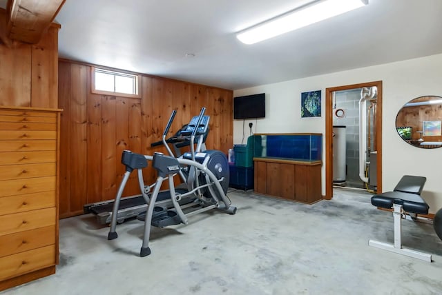 workout room with water heater and wood walls