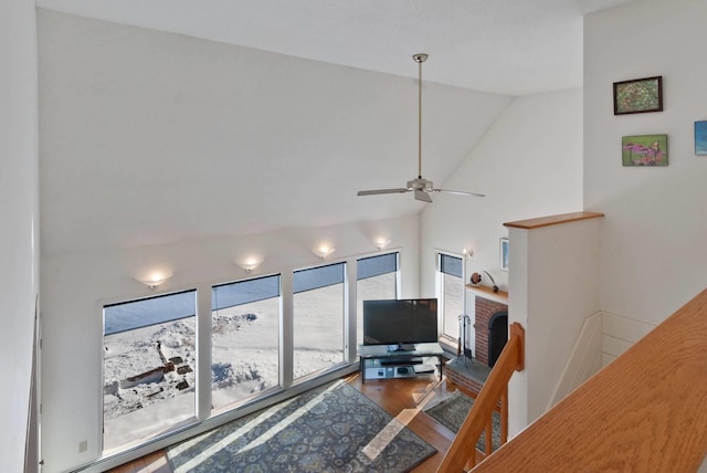 living room featuring a brick fireplace, high vaulted ceiling, hardwood / wood-style floors, and ceiling fan