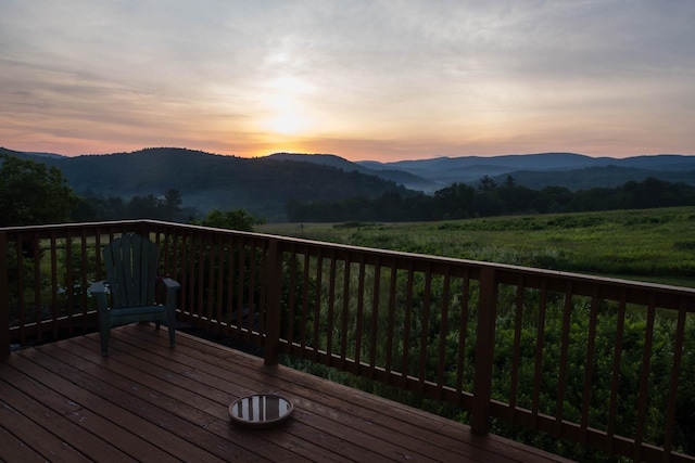 deck at dusk featuring a mountain view