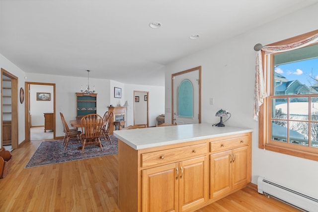 kitchen with baseboard heating, hanging light fixtures, light brown cabinetry, kitchen peninsula, and light wood-type flooring