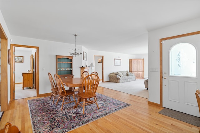 dining area with an inviting chandelier and light hardwood / wood-style floors