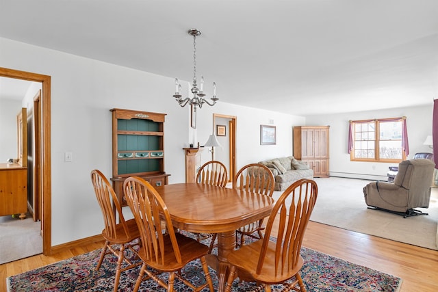 dining space featuring hardwood / wood-style flooring, a baseboard heating unit, and a chandelier