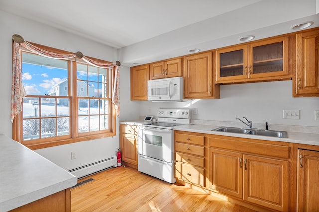 kitchen featuring sink, white appliances, light hardwood / wood-style floors, and baseboard heating