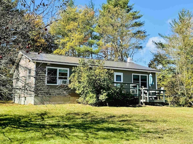 exterior space with a wooden deck and a lawn