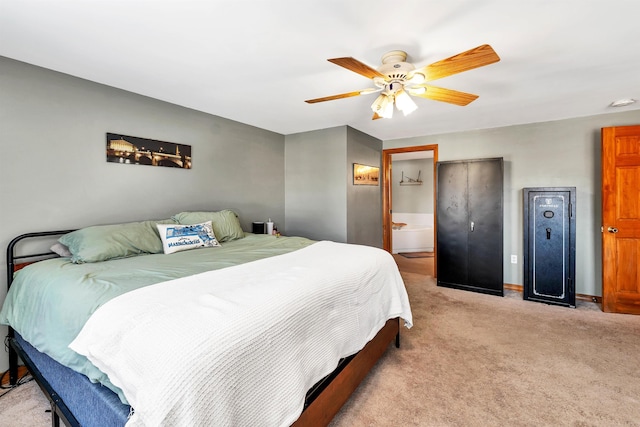 bedroom with ceiling fan, connected bathroom, and light carpet