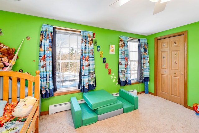 playroom featuring a baseboard radiator, carpet floors, and ceiling fan