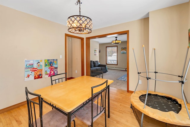 dining area featuring light hardwood / wood-style floors and a baseboard heating unit