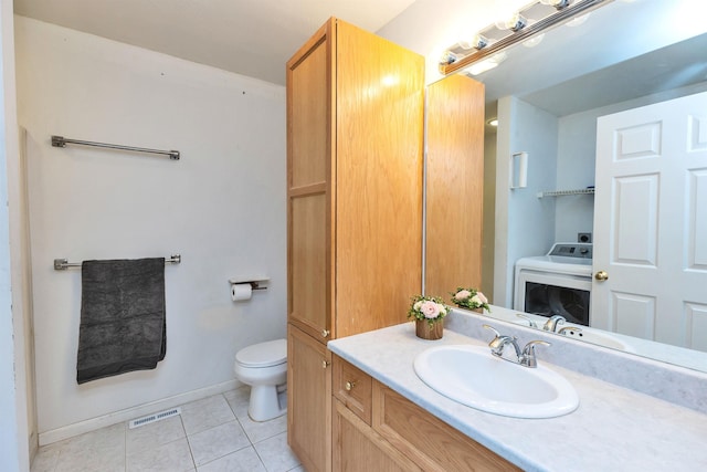 bathroom with toilet, tile patterned flooring, vanity, and washer / dryer