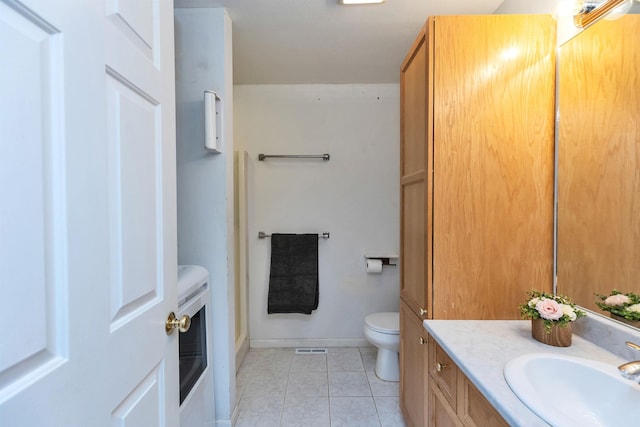 bathroom with toilet, tile patterned floors, and vanity